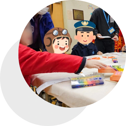 a group of children sitting at a table with an adult wearing a mask